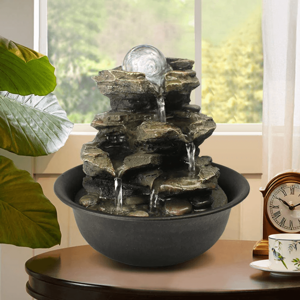 A tabletop fountain with cascading water over natural stone-like tiers